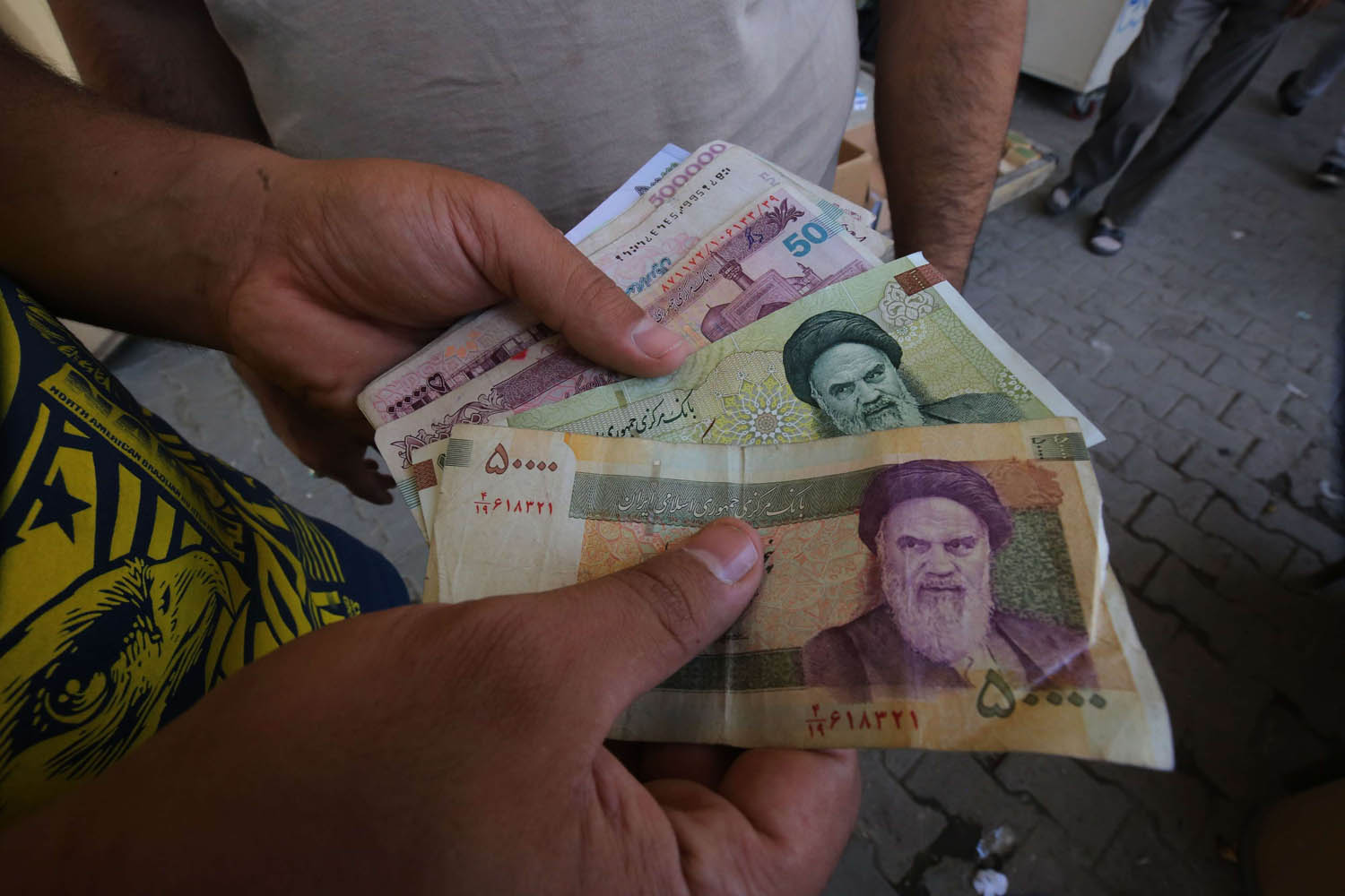 عراقيون يتداولون عملة إيرانية في شوارع بغداد