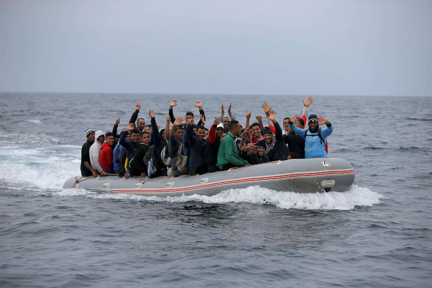 Migrants are seen on a dinghy as they cross the Strait of Gibraltar sailing from the coast of Morocco