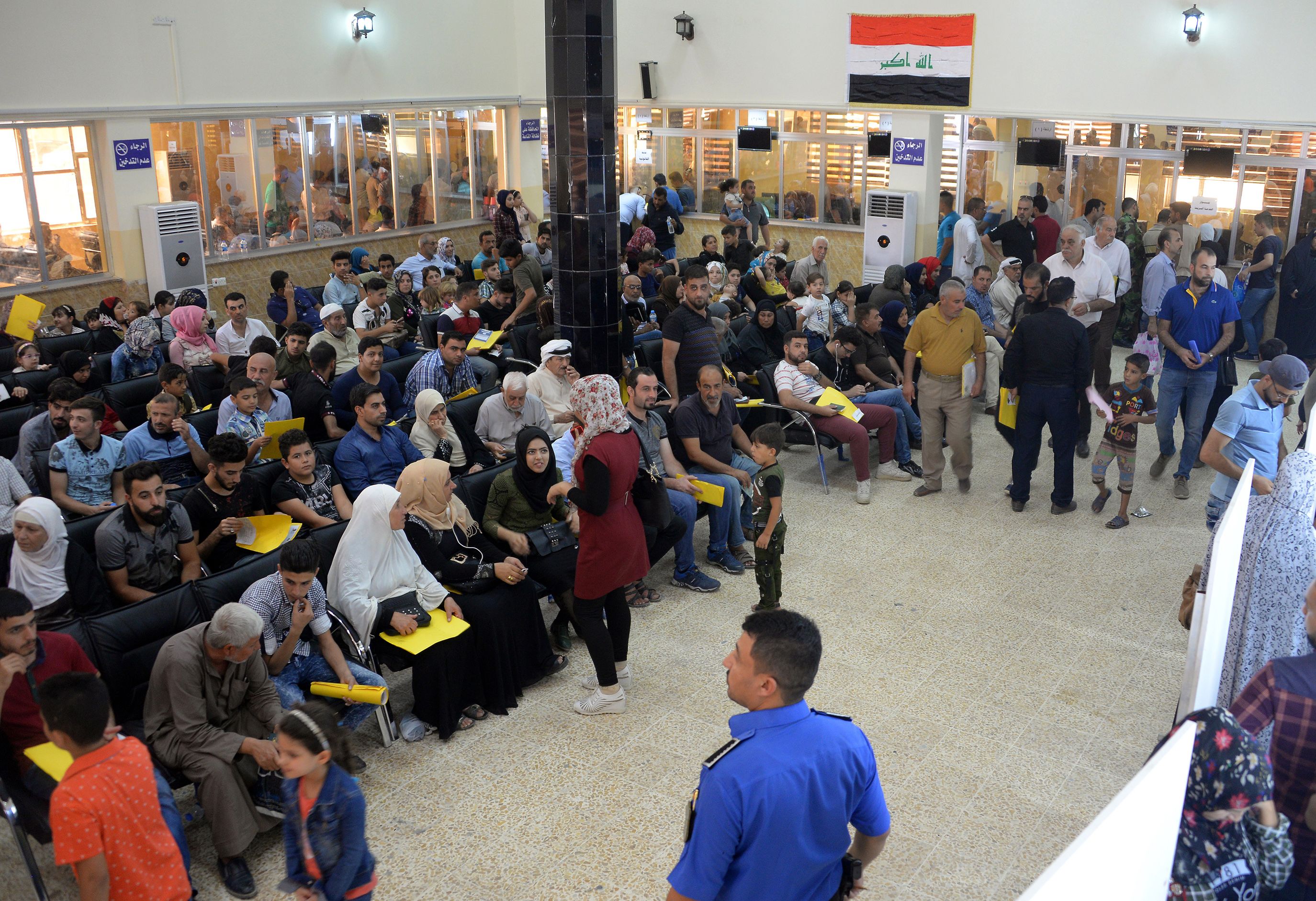 Iraqis wait at the Nineveh governorate building in Iraq's second city of Mosul.