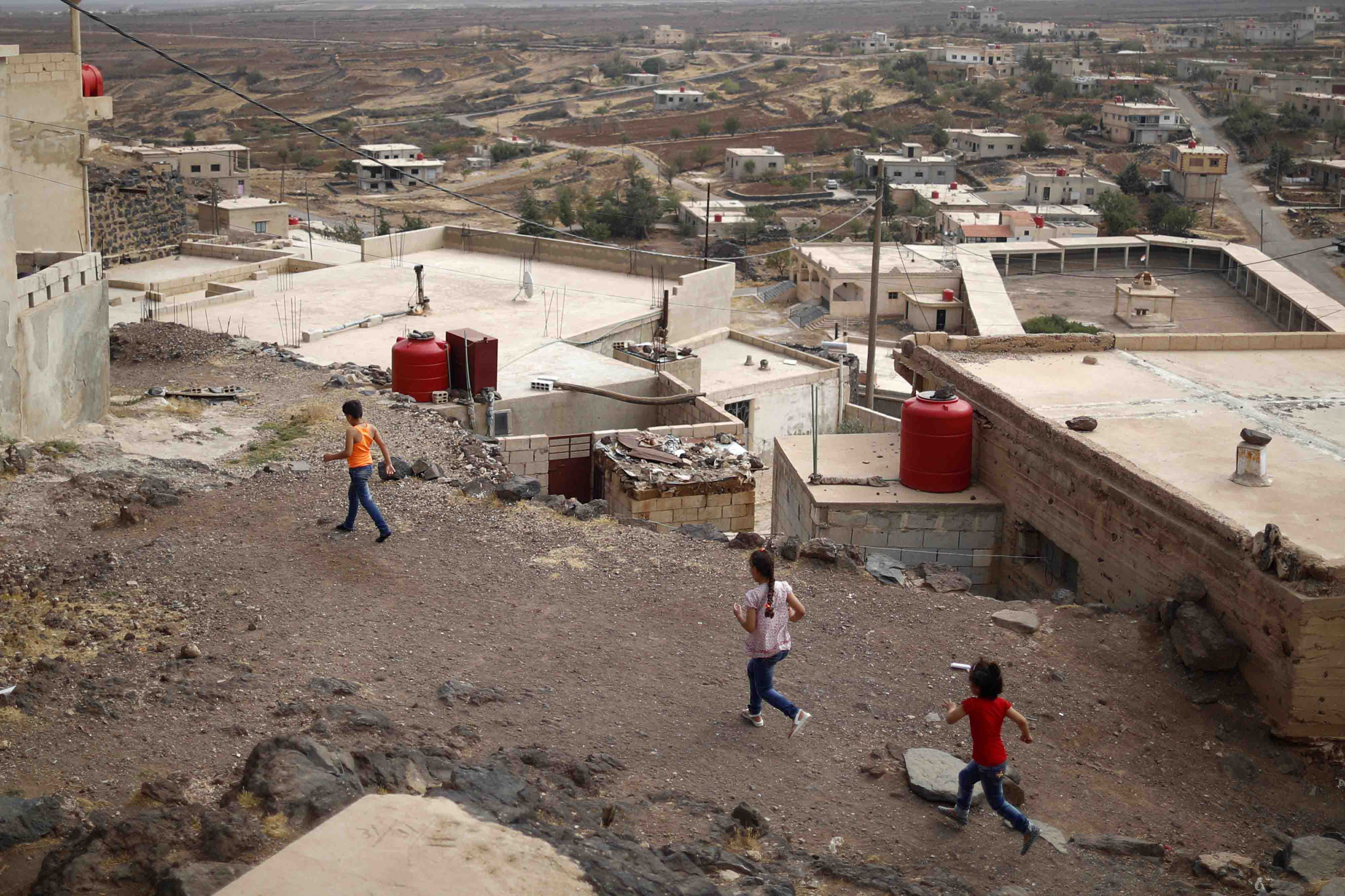 Druze children run at the village of Shreihi in the southern province of Sweida, Syria