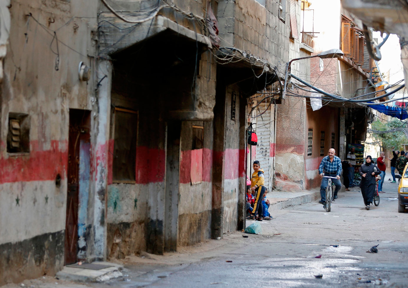 People walk in a street in Tadamun neighbourhood.
