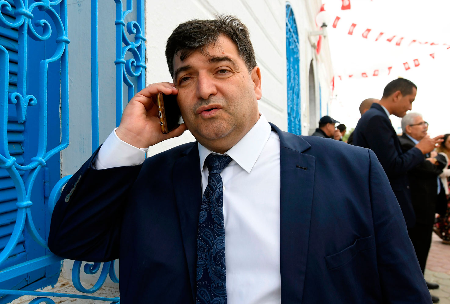Rene Trabelsi speaking on the phone outside the Ghriba Synagogue in Djerba.