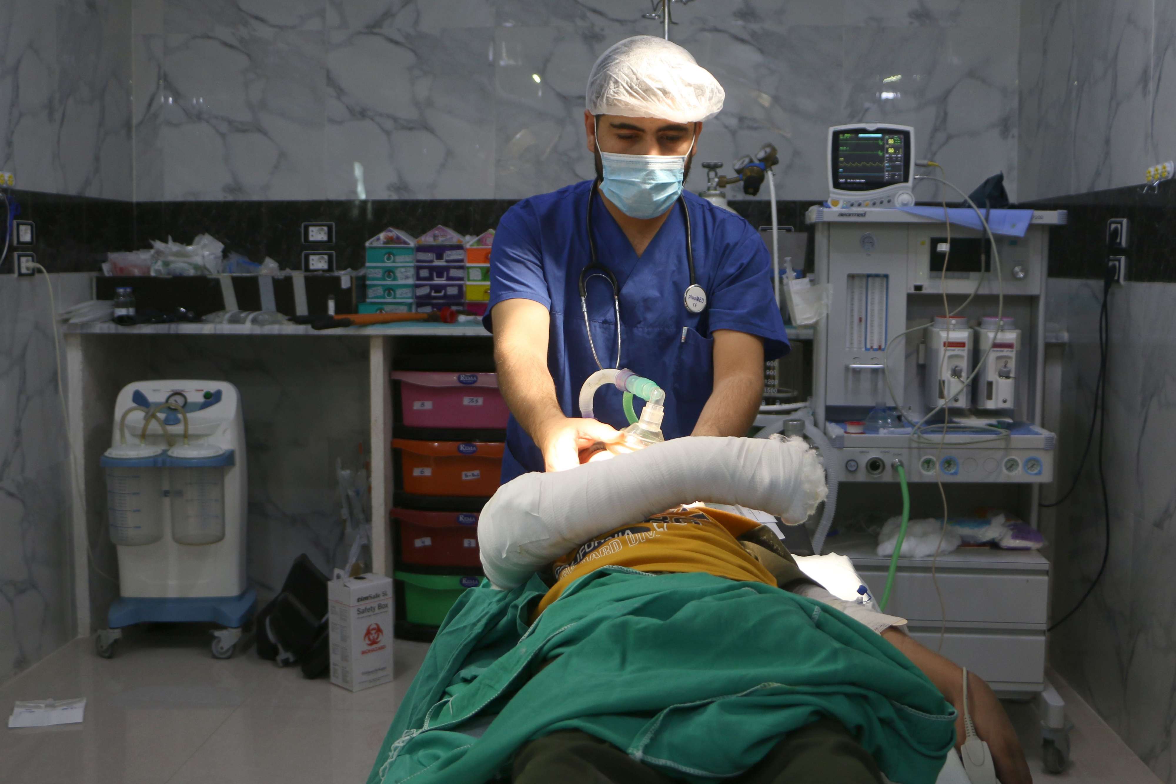 A Syrian doctor checks a child injured during a bombing after a surgery at a hospital in Syria's rebel-held Idlib province on September 10, 2018.
