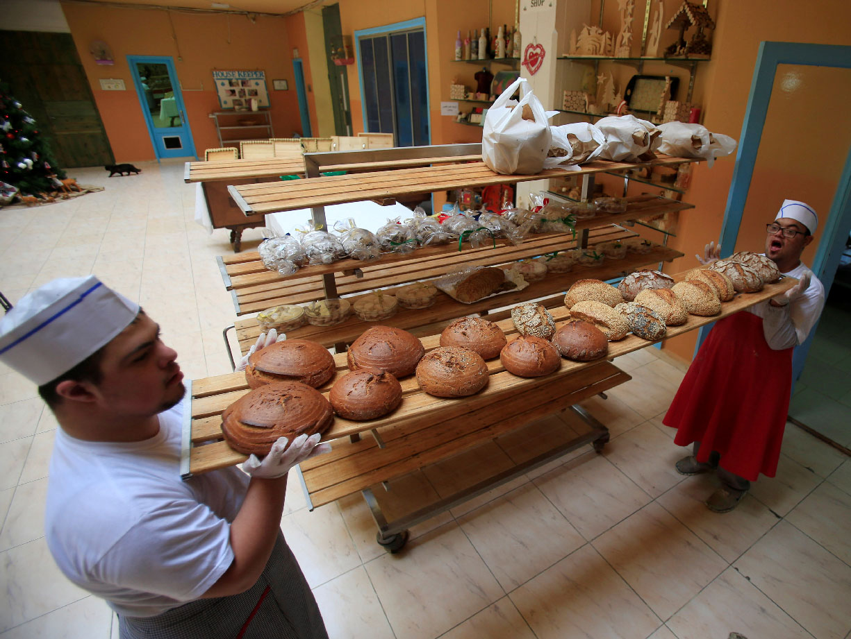 Men with special needs hold bread in the southern city of Tyre, Lebanon December 18, 2018.