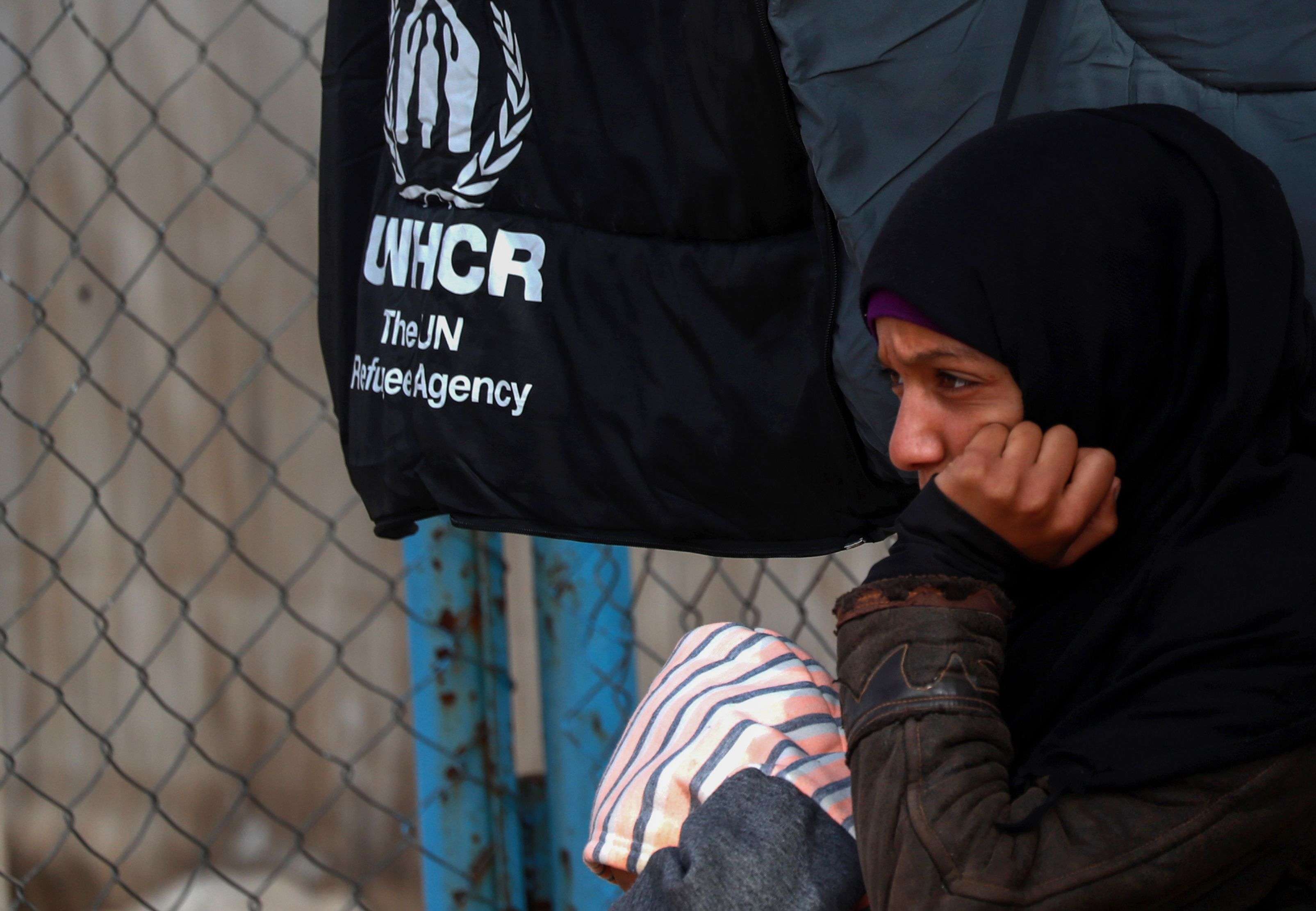 A Syrian displaced girl sits by a fence inside the Internallly Displaced Persons (IDP) camp of al-Hol in al-Hasakeh governorate in northeastern Syria on December 8, 2018.