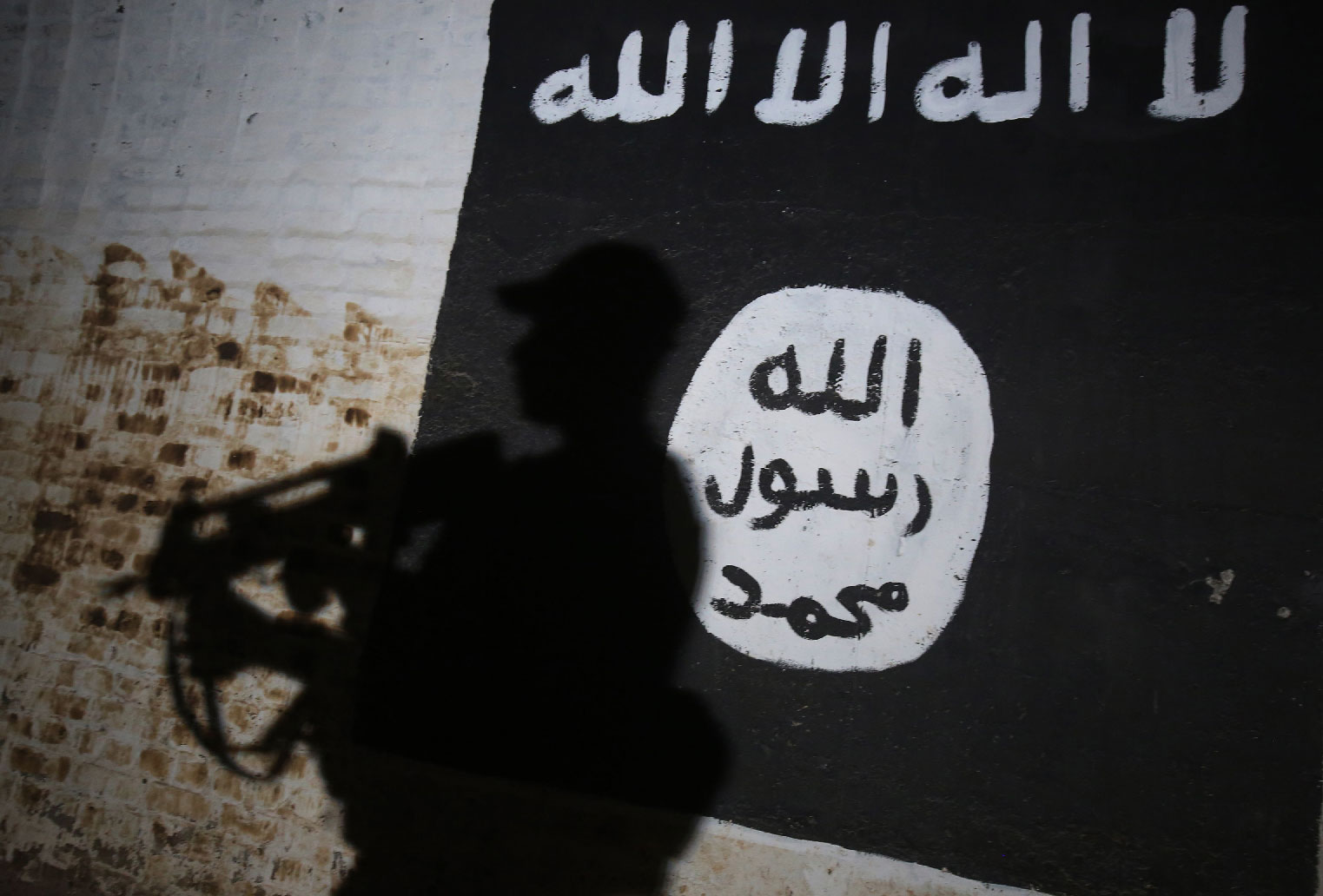 A member of the Iraqi forces walks past a mural bearing the logo of the Islamic State (IS) group in a tunnel that was reportedly used as a training centre by the jihadists in the village of Albu Sayf, on the southern outskirts of Mosul.