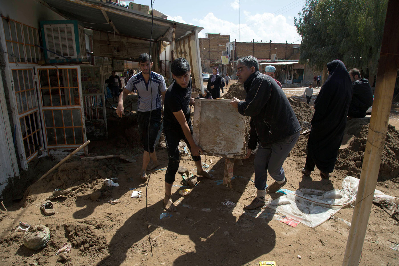 Iranians carry furnitures in a flooded street in the city of Poldokhtar in the Lorestan province, on April 02, 2019.
