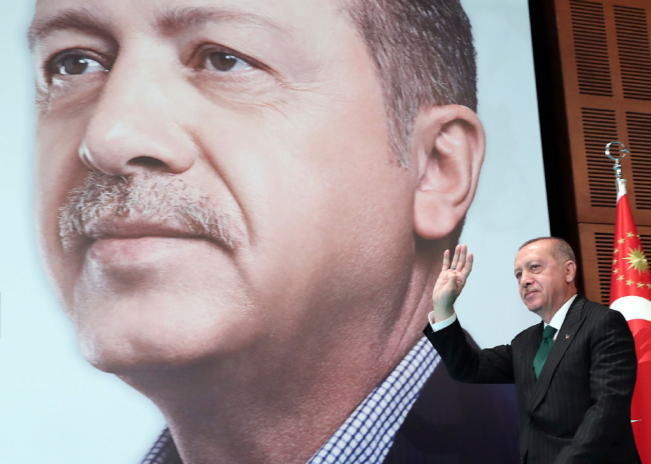 Erdogan gestures as he arrives to deliver a speech to members of his ruling Justice and Development Party
