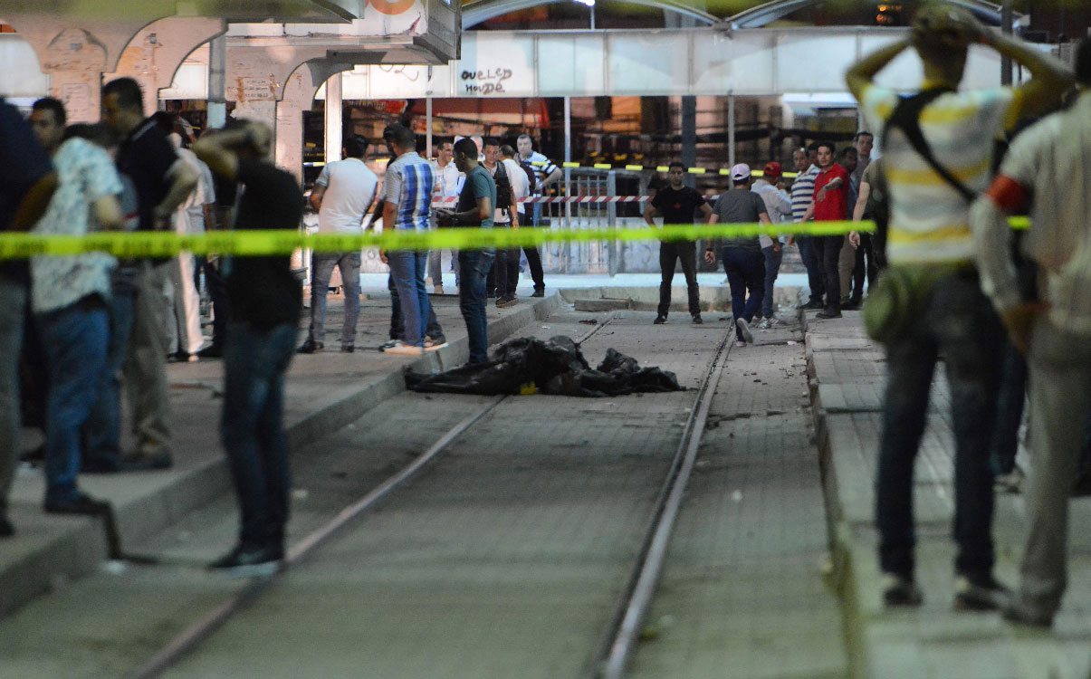 Onlookers gather at the scene outside a metro station where a man blew himself up