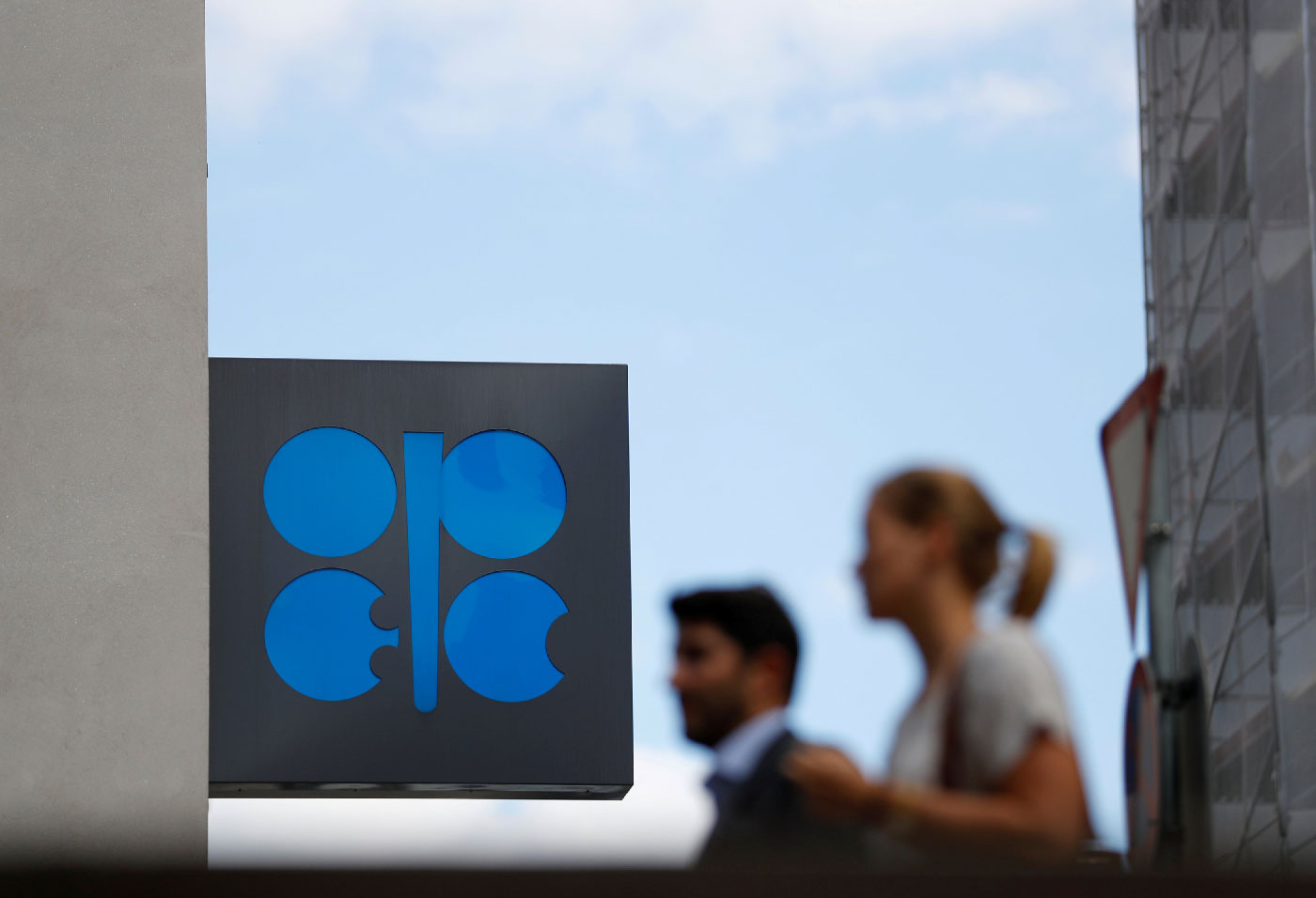 People walk outside the OPEC headquarters in Vienna