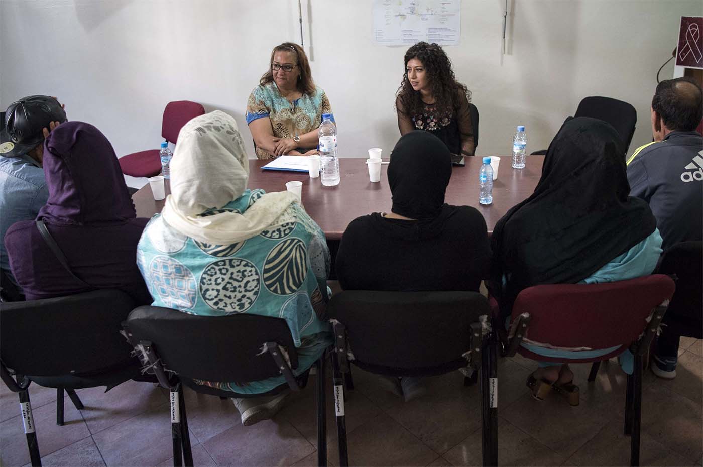 Two members of Morocco's ALCS talk with HIV patients at Ibn Rochd Hospital