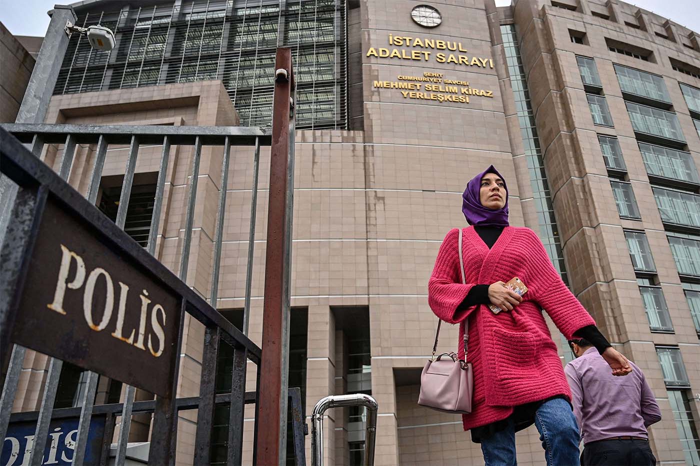 People walk outside of Istanbul's courthouse during the trial of dozens of defendants