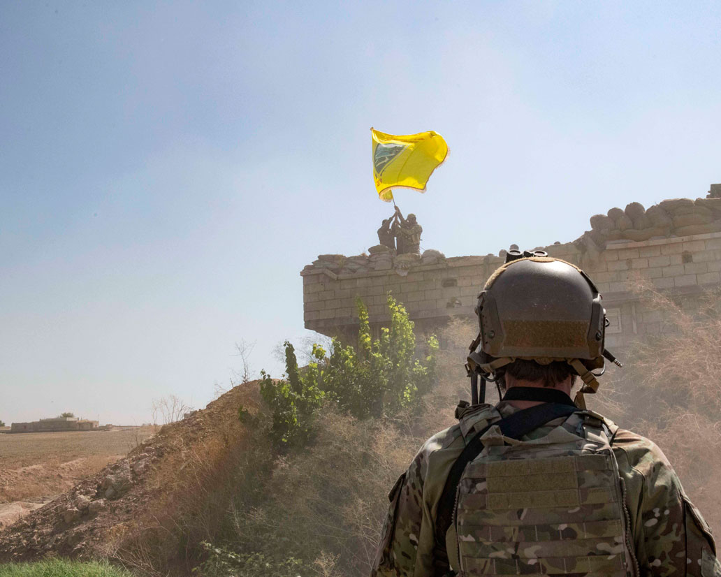 US Soldier oversees members of the Syrian Democratic Forces as they demolish a Kurdish fighters' fortification near Syria's border with Turkey