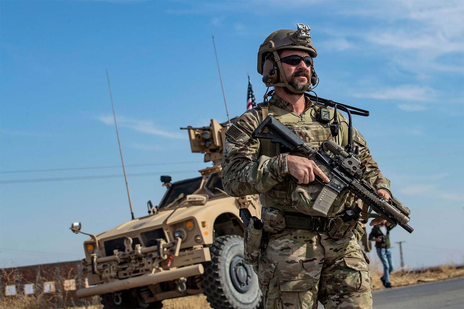 A US soldier stands by an armoured vehicle during a patrol of the northern countryside of the northeastern Syrian town of al-Malikiyah 