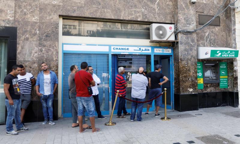 People change money at a currency exchange bank in Tunis
