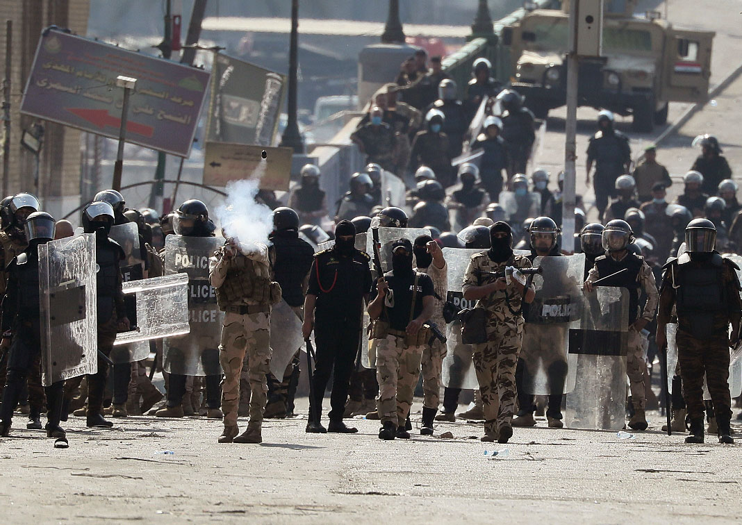 Iraqi riot police fire tear gas to disperse anti-government protesters gathering on the al- Shuhada (Martyrs) bridge
