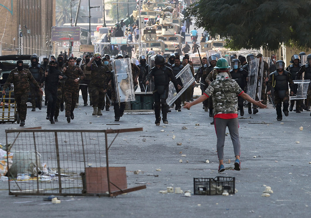 Iraqi anti-riot police try to prevent anti-government protesters from crossing the al- Shuhada (Martyrs) bridge