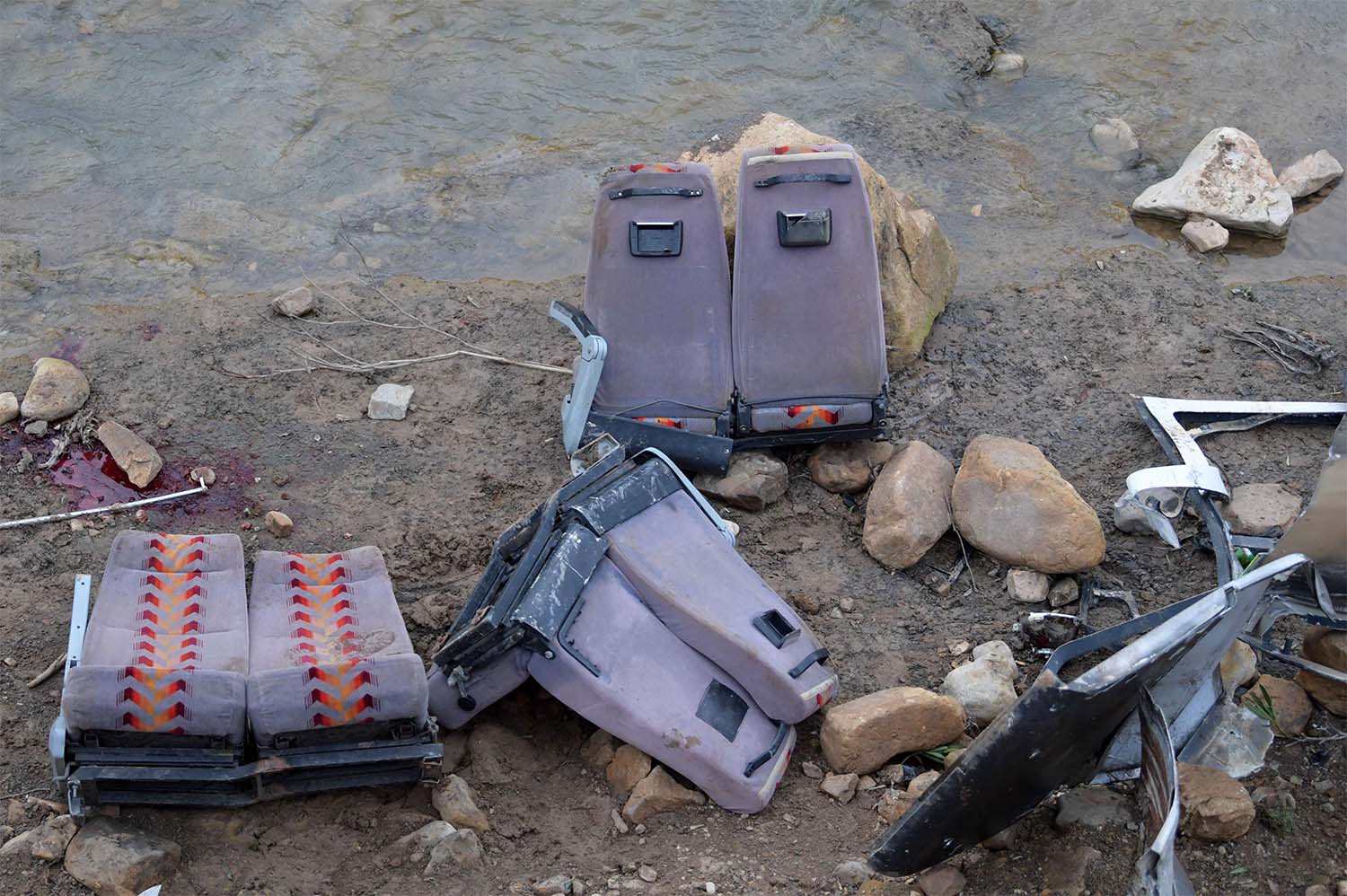The remains of the bus in the ravine near a river bed