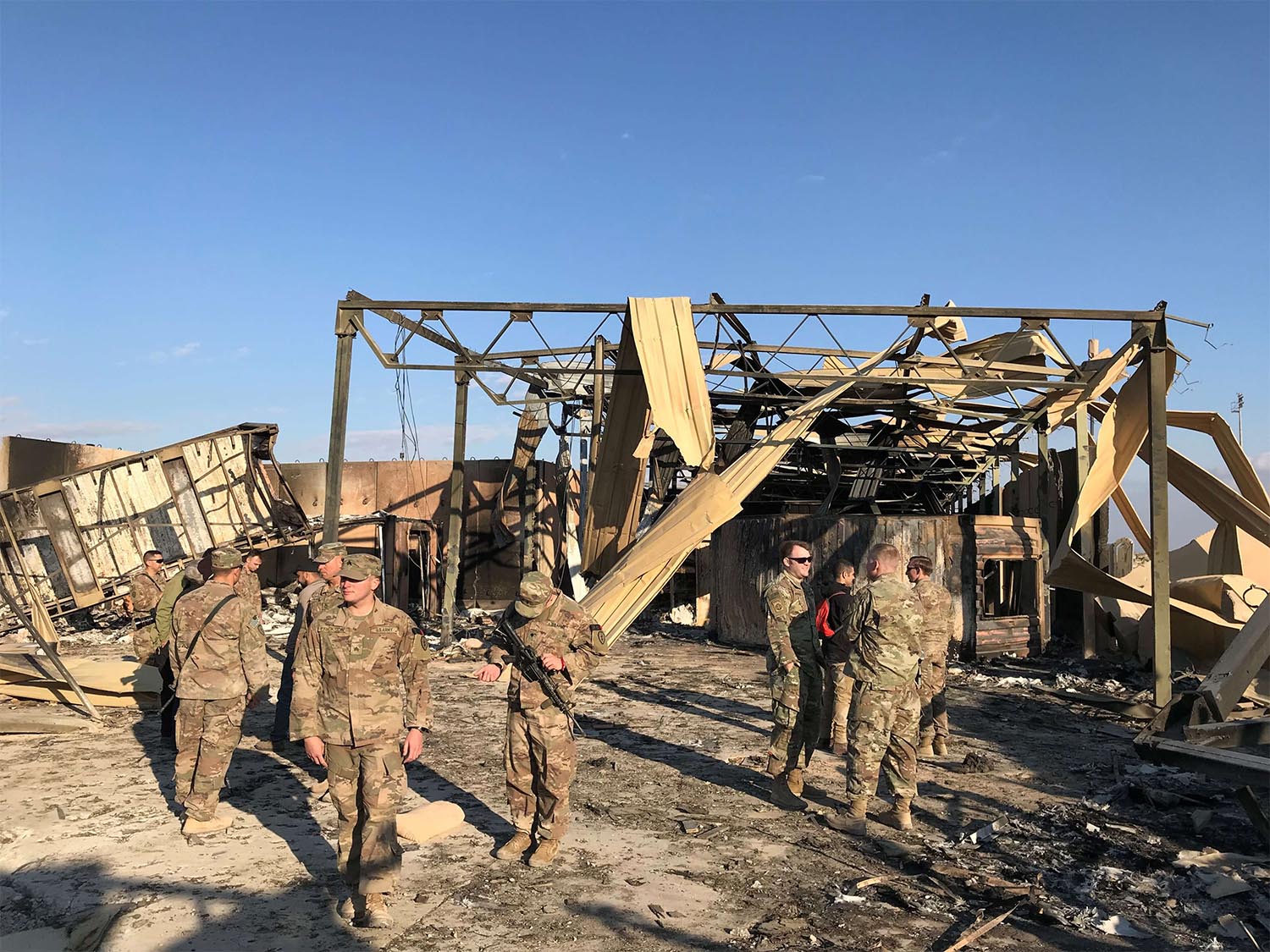 US soldiers inspect the site where an Iranian missile hit at al-Asad air base