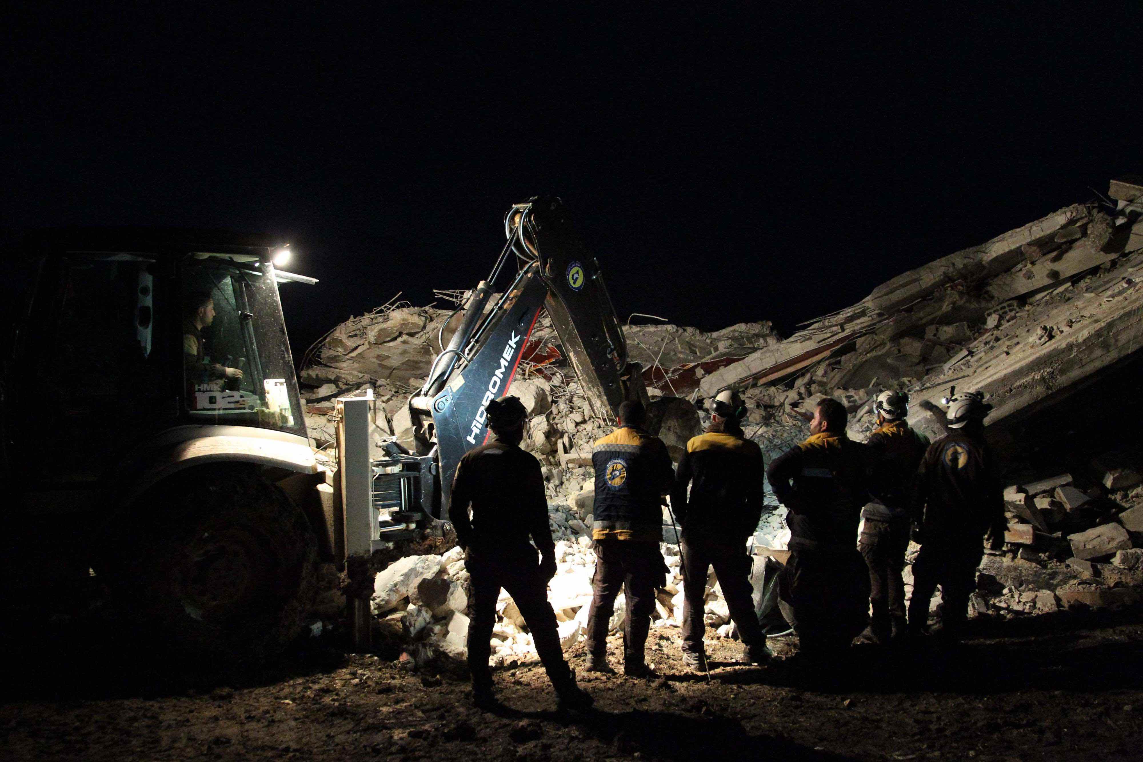 Members of the Syrian Civil Defence, also known as the White Helmets, search for survivors following an air-strike on the flashpoint town of Maaret al-Numan