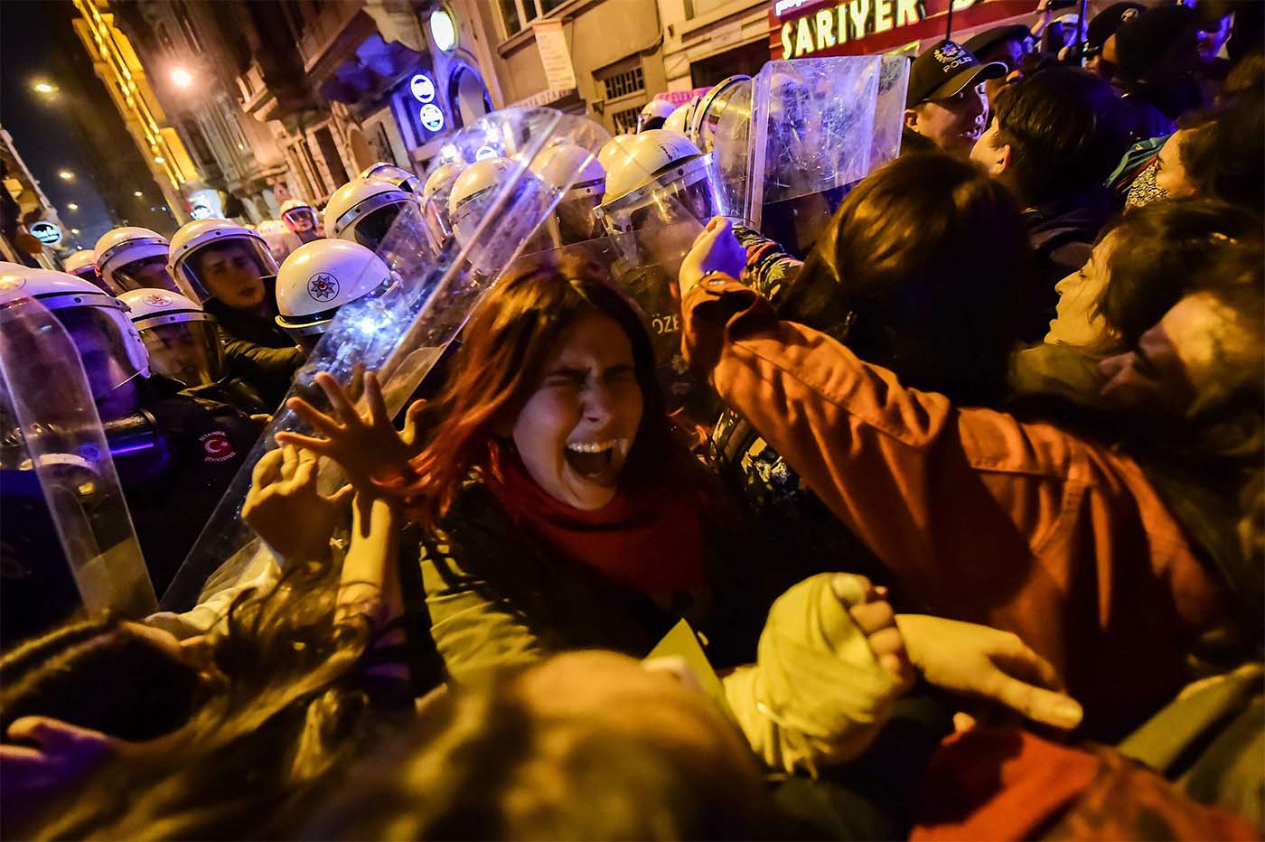 Turkish anti-riot police officers push back women during a rally marking International Women's Day on Istiklal avenue in Istanbul 