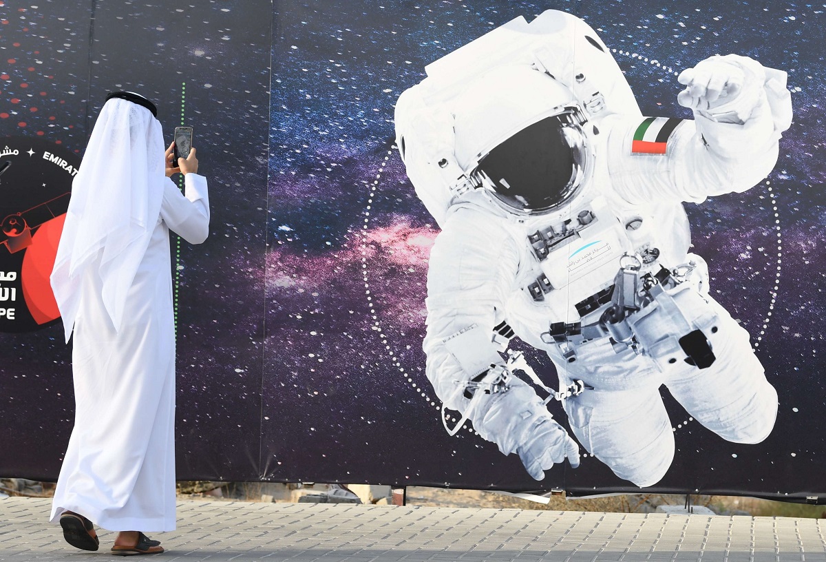 اماراتي يلتقط صورة لرائد فضاء يحمل العلم الوطني الإماراتي خارج مركز محمد بن راشد للفضاء في دبي