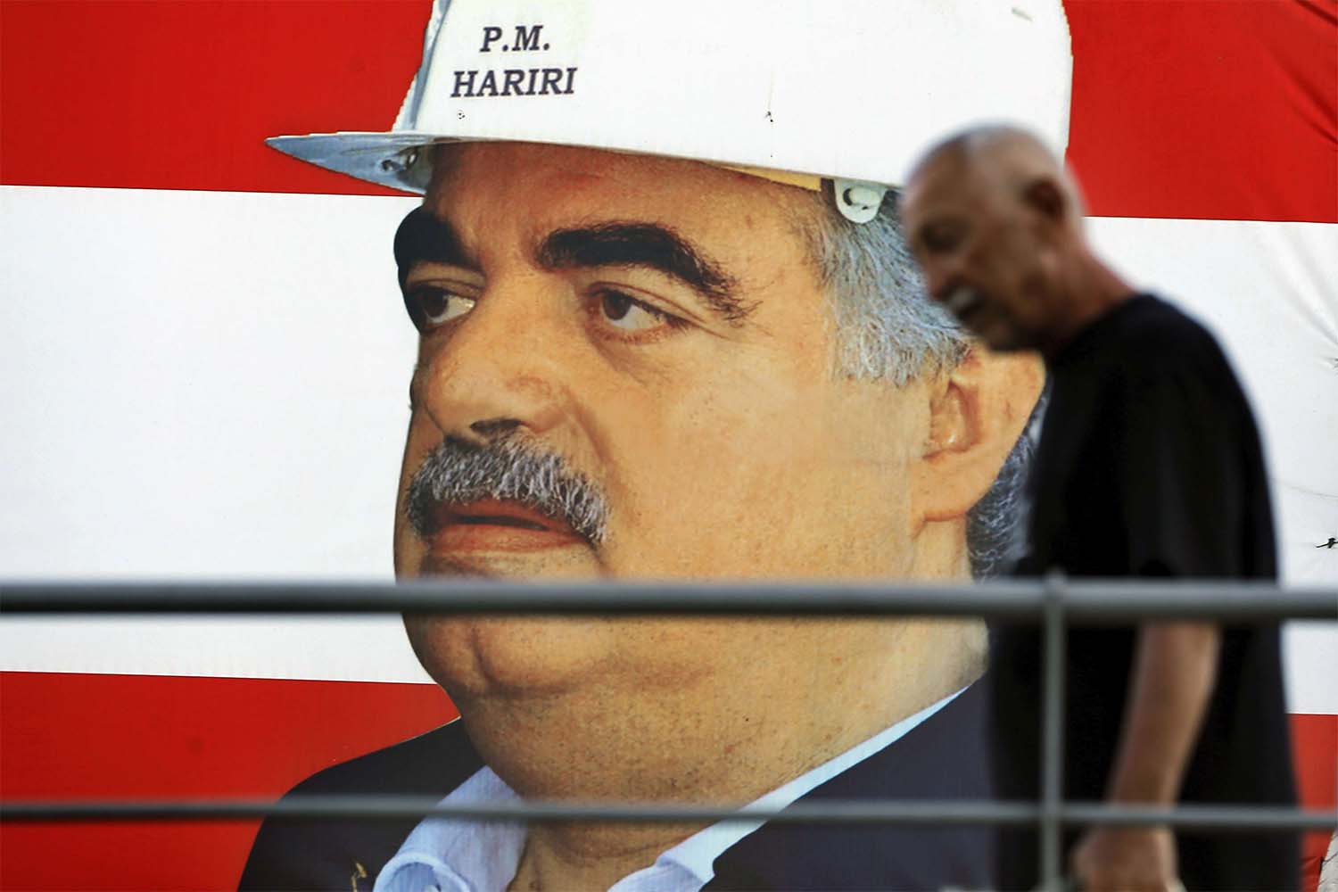 A man passes a poster of slain Lebanese Prime Minister Rafik Hariri in Beirut