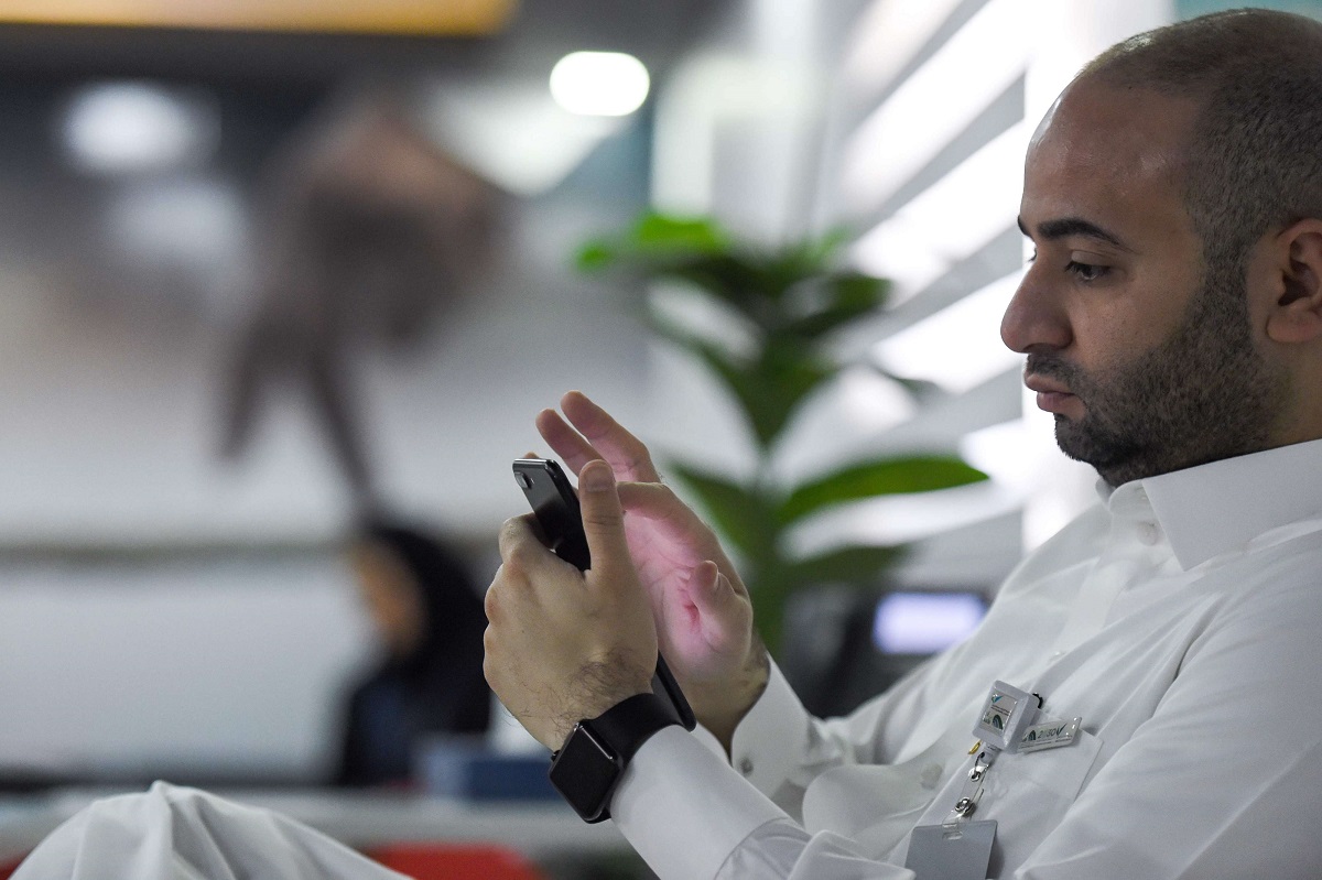 موظف سعودي يتصفح هاتفه في مكتبه بالرياض