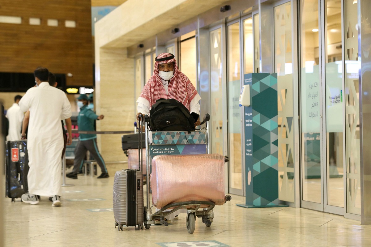 مواطن سعودي يجر حقائبه لدى وصوله إلى مطار الملك خالد الدولي