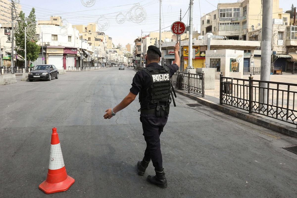 شرطي اردني يحرس نقطة تفتيش خلال حظر تجول في المملكة