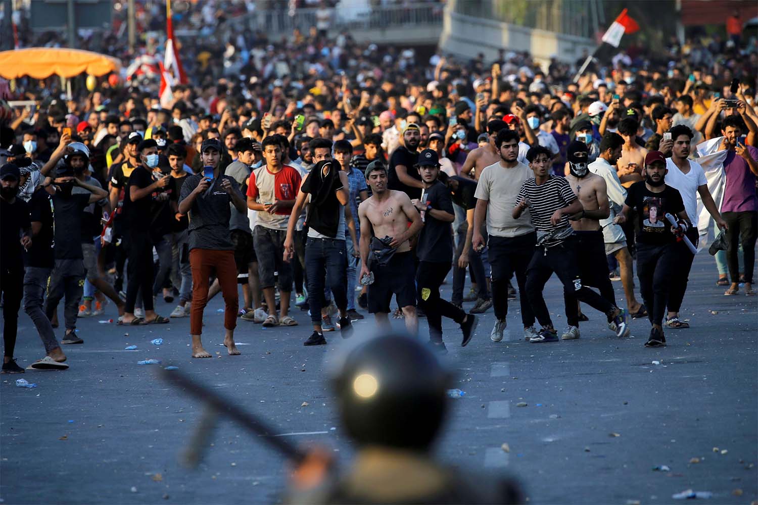 Demonstrators face security forces during an anti-government protest in Baghdad