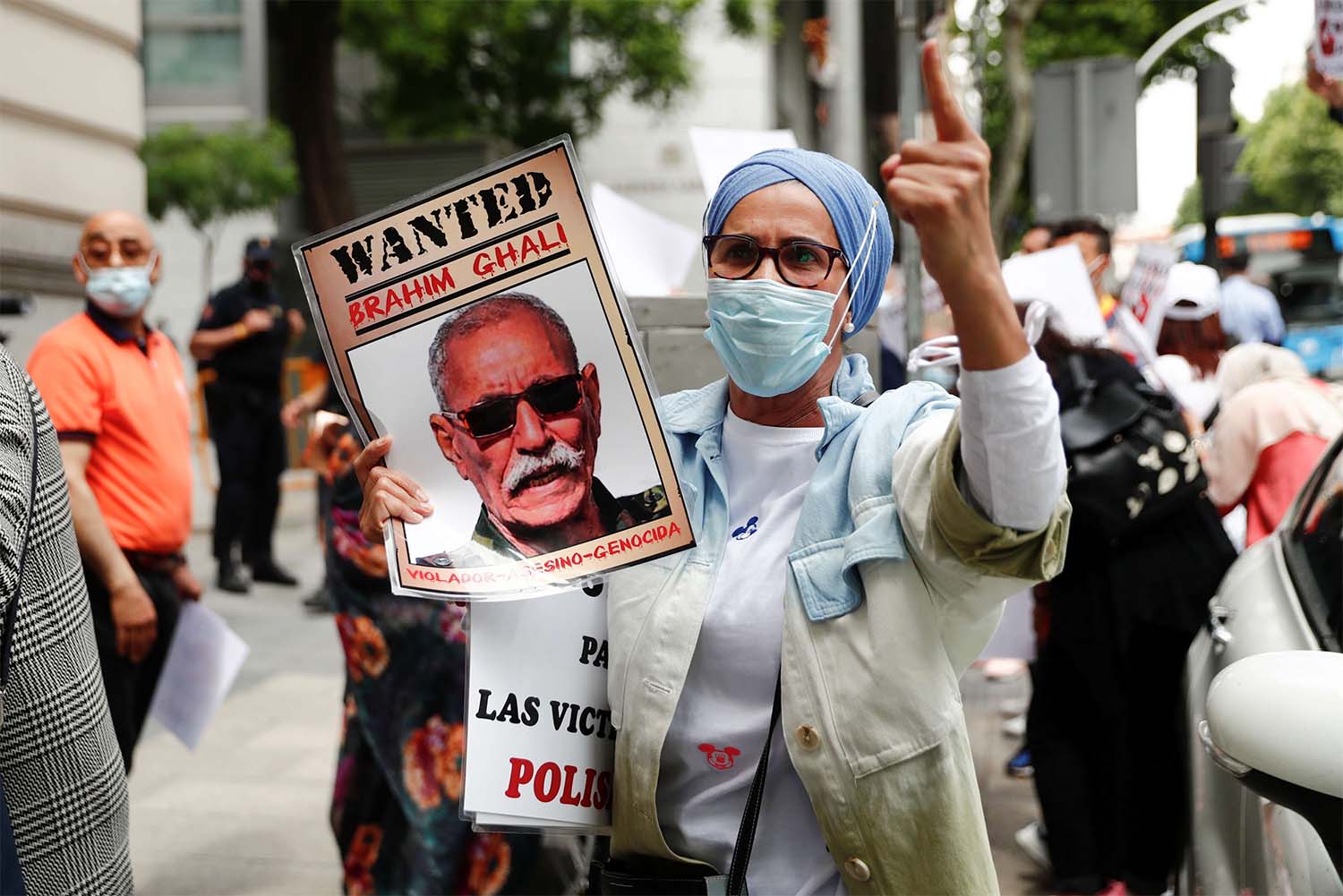 People hold placards as they protest against Brahim Ghali outside the High Court