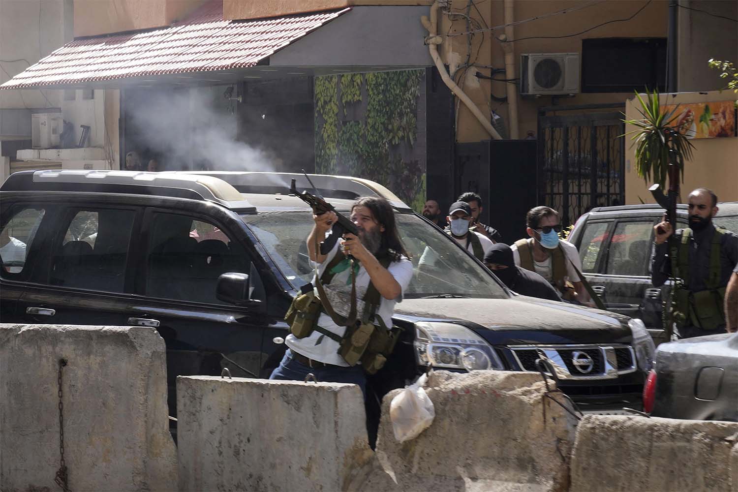 Heavily armed Hezbollah supporters react with to gunfire with gunfire