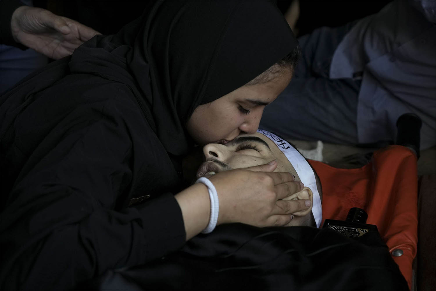 A mourner kisses the body of Palestinian Bara Lahlouh, 24, during his funeral at his family home in Jenin