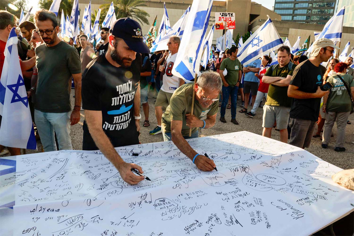 Israeli military reservists sign a declaration announcing the suspension of their voluntary reserve duty