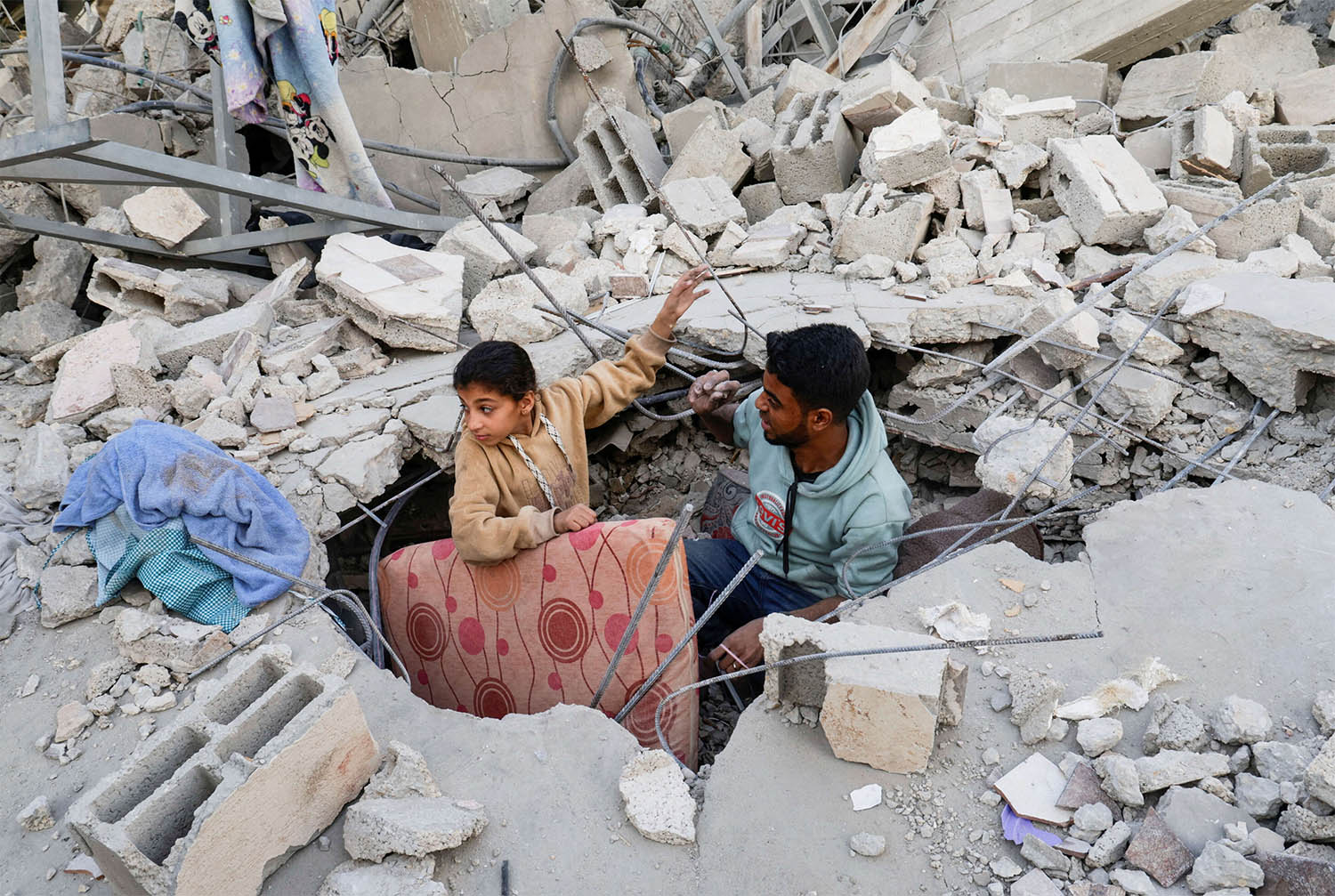 Palestinians inspect the site of an Israeli strike on a house, in Khan Younis 