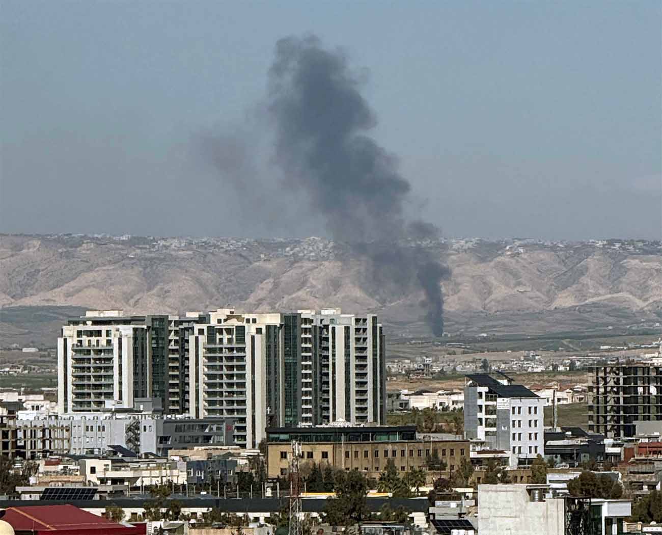 Smoke rises from the site of a drone crash on the outskirts of Erbil