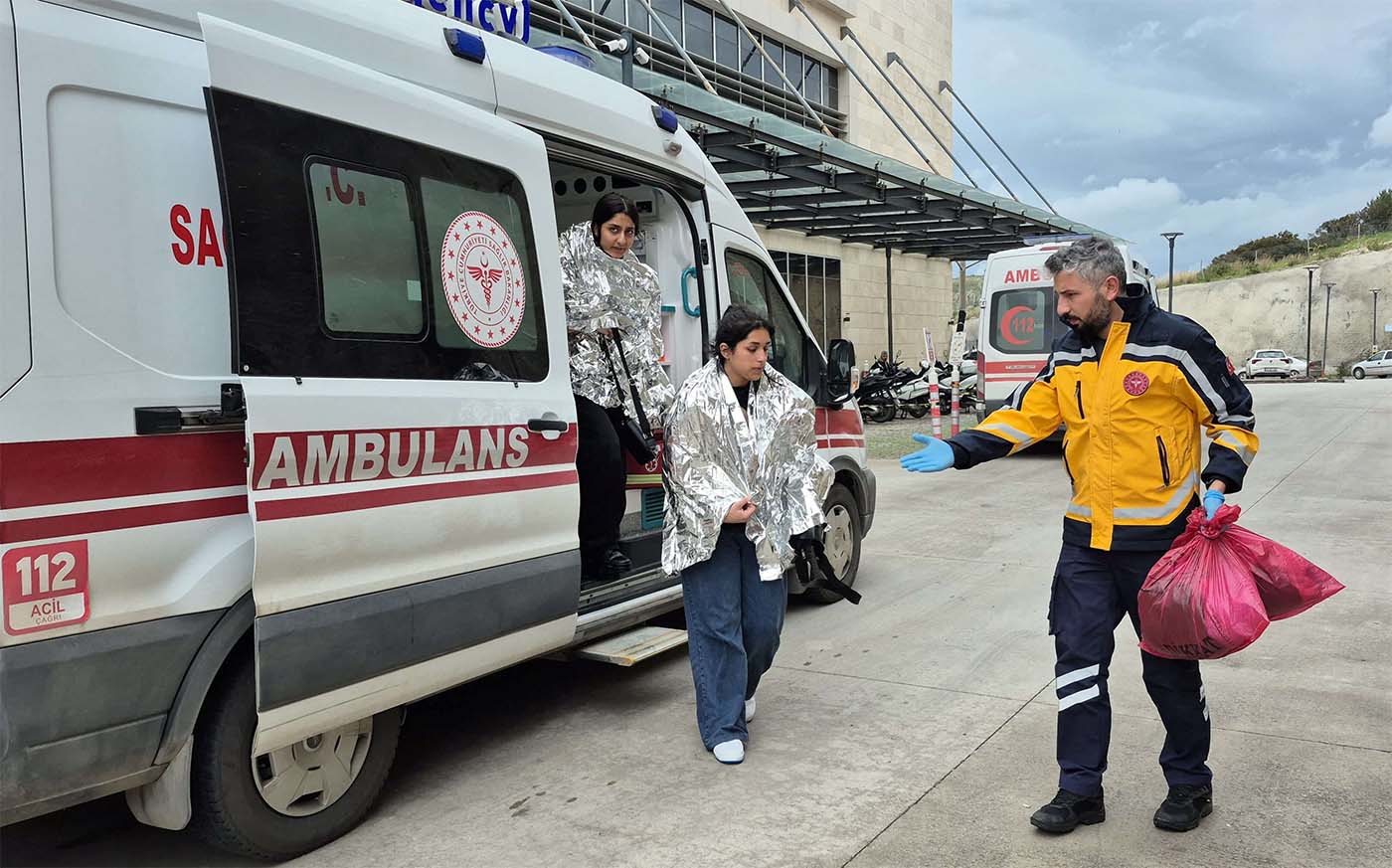 People rescued after a migrant boat sank off Turkey’s Aegean coast get out of an ambulance upon arrival at a hospital in Bodrum