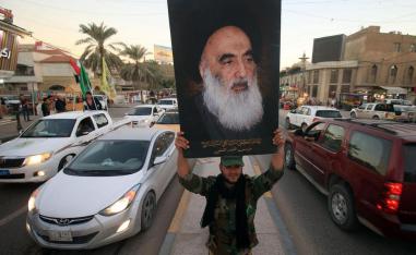 أحد اعضاء الحشد الشعبي يرفع صورة السيستاني