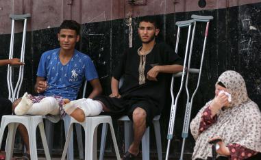 فلسطينيون اصيبوا في ارجلهم في المواجهات الأخيرة مع الاسرائيليين يحضرون مأتما لفلسطيني قتل في المواجهات