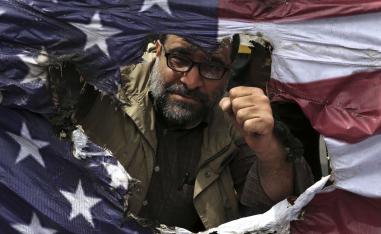 متظاهر إيراني في طهران يحرق علما أميركيا