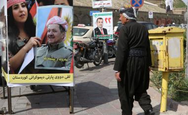كردي يمر أمام ملصف انتخابي للحزب الديمقراطي الكردستاني في أربيل
