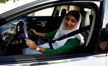    مرأة سعودية تبتسم خلف مقود سيارة