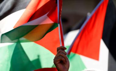 فلسطيني يرفع أعلام بلاده في رام الله