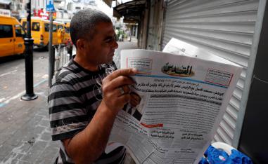 فلسطيني يقرأ صحيفة في رام الله