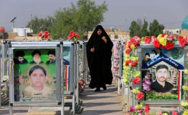 عراقية تمر بين القبور في مقبرة وادي السلام في النجف