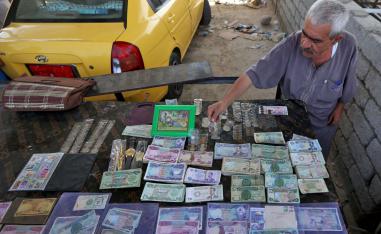 تاجر عراقي يعرض أوراق نقدية عراقية من مراحل حكم مختلفة
