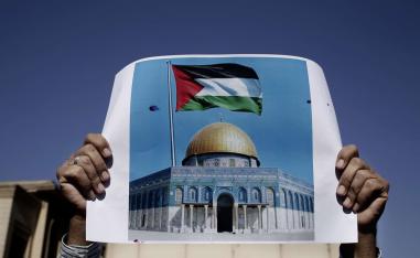 متظاهر فلسطيني يرفع صورة للقدس
