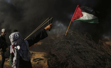 طفل فلسطيني يرمي حجارة بمصيادته على الاسرائيليين