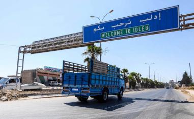 شاحنة تمر تحت إشارة مرورية في الطريق المؤدي إلى إدلب